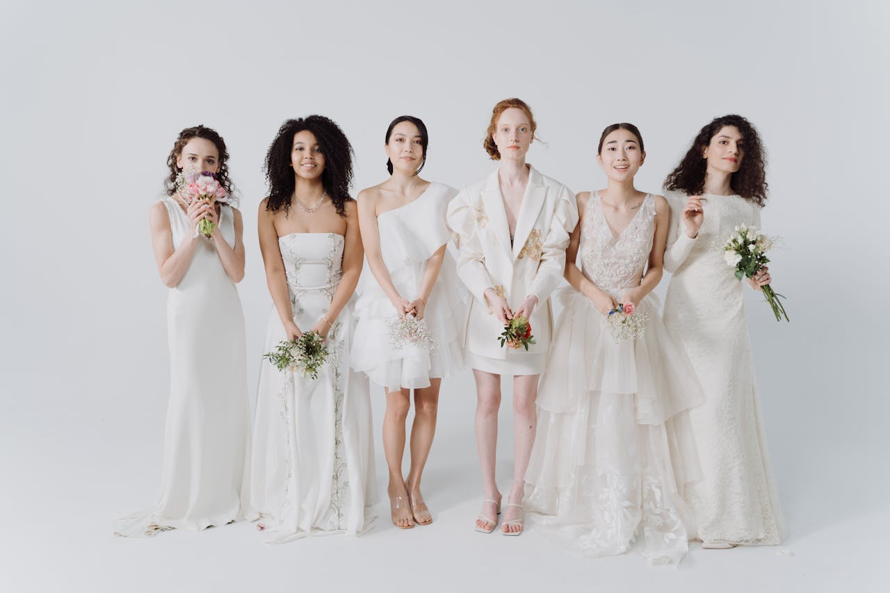 Elegant and diverse brides posing in various white wedding dresses holding bouquets.